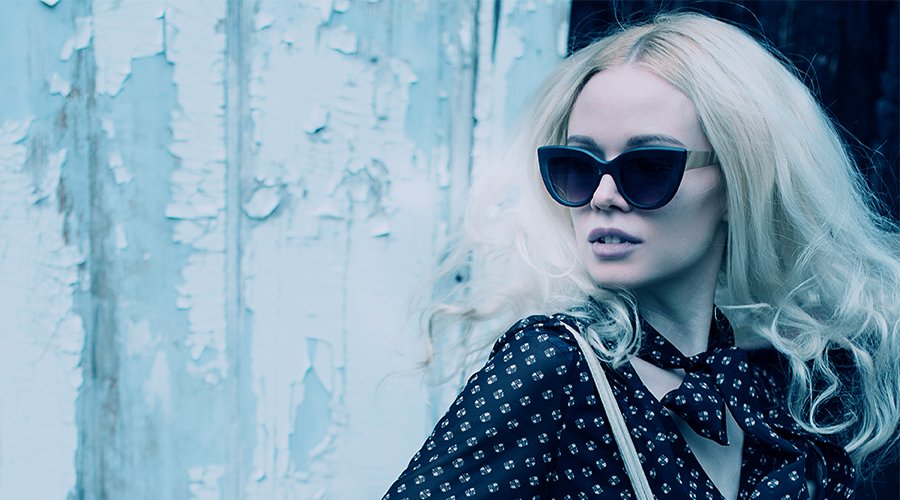 a blonde woman in sunglasses in the style of movie Atomic Blonde