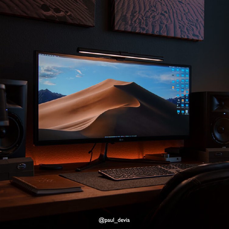 There is a desk setup with a ScreenBar on the monitor.
