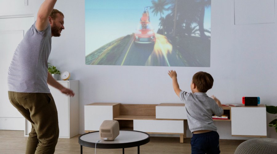 Father playing with his kid on a portable projector for edutainment time