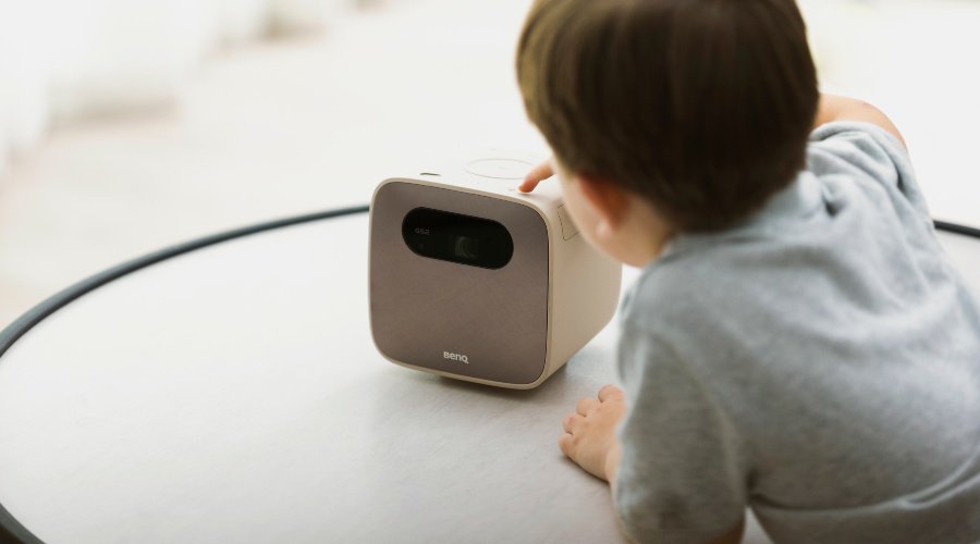 A child playing with a portable mini projector